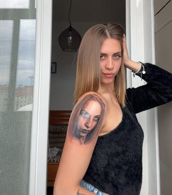 Ragazza si tatua il proprio viso sulla spalla e viene criticata