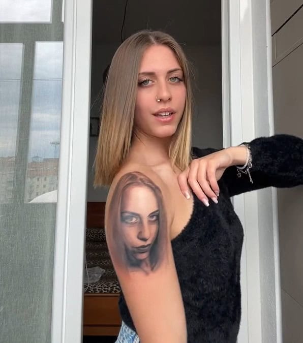 Ragazza si tatua il proprio viso sulla spalla e viene criticata